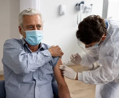 adult man getting a booster dose of the covid 19 vaccine at the hospital