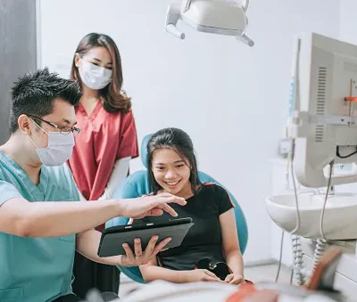 asian chinese male dentist explaining tooth x rays to a patient