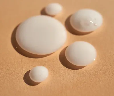 drops of white milk consistency on a beige background