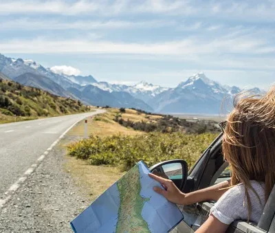 portrait of young woman in car looking at map