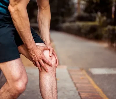 the athlete holds on to his knee as he feels pain