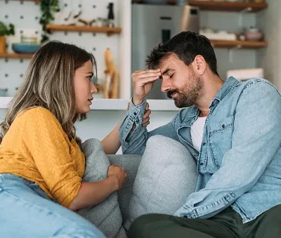 worried couple talking together in the living room at home